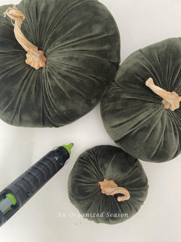 Three velvet pumpkins and a hot glue gun. 