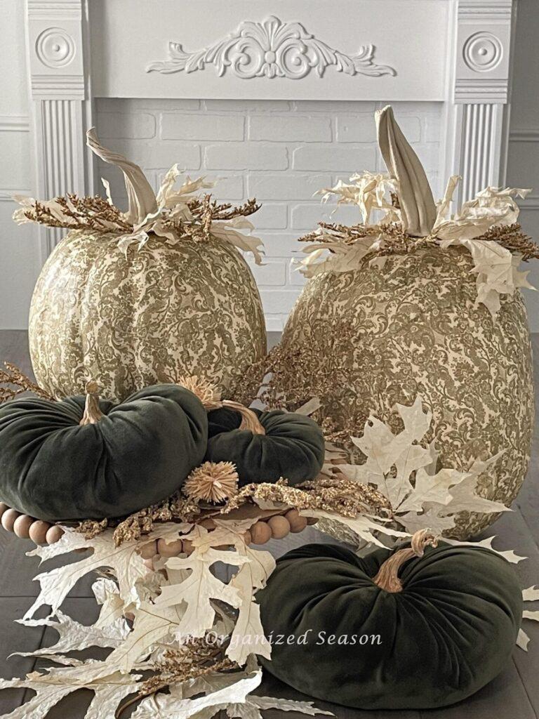 Three green velvet pumpkins styled with two decoupage pumpkins.