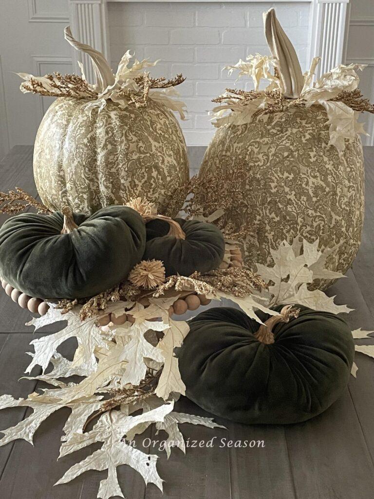 A table display with two decoupage and three velvet pumpkins. 