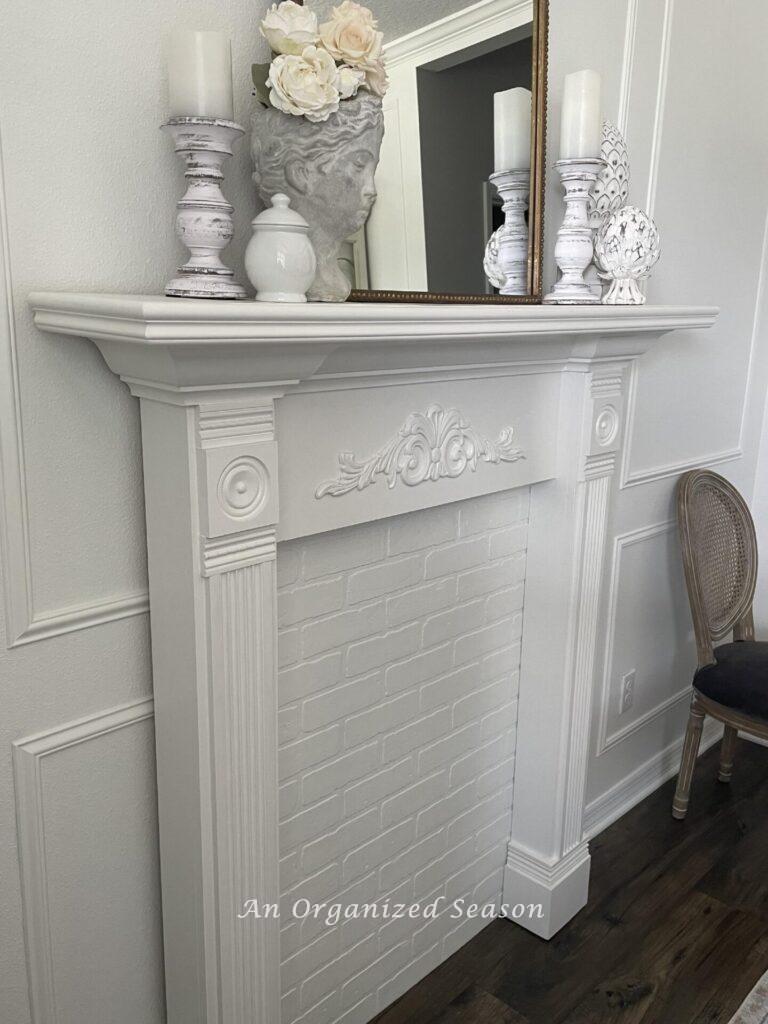 Step two of our dining room makeover was to add a DIY faux white fireplace mantle.
