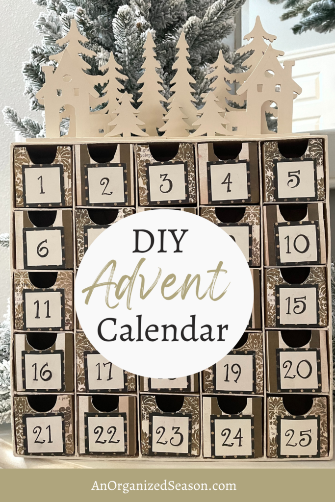 Advent Calendar with 25 boxes and a wood cutout of trees and houses on top. 