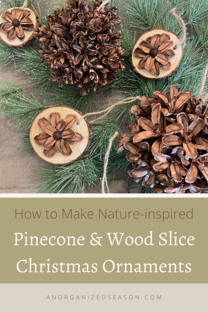pinecone and wood slice ornaments laying on greenery