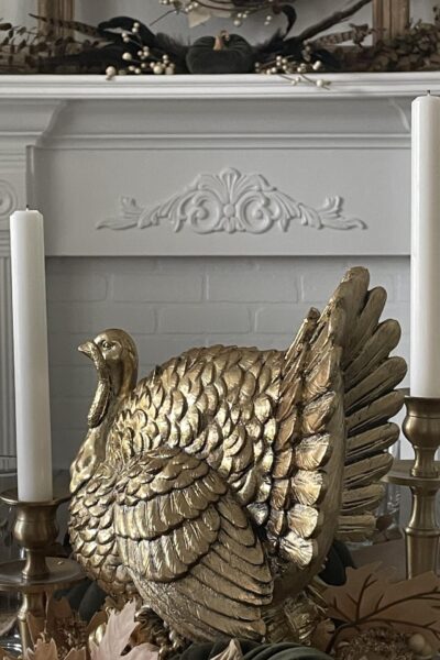 Gold turkey between two white candles.