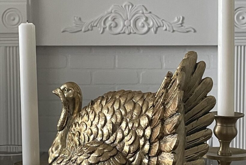 Gold turkey between two white candles.