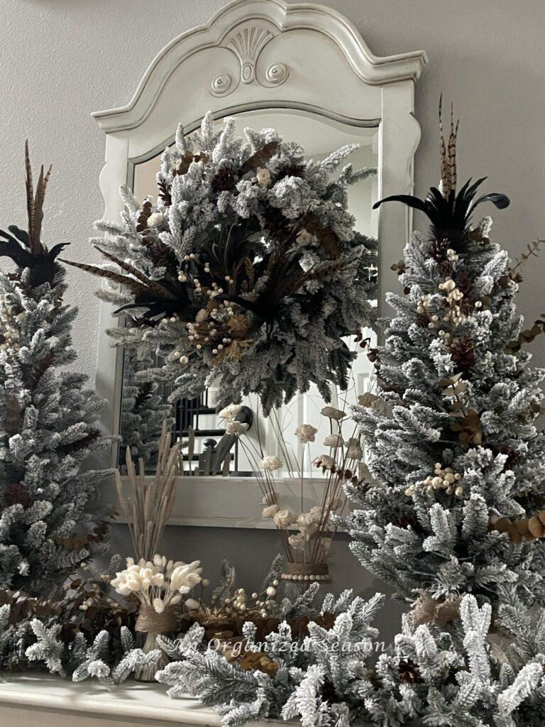 A wreath, two trees, and a garland decorated for Thanksgiving.