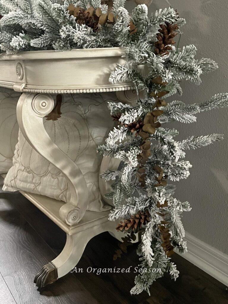 A flocked garland hanging off a console table.