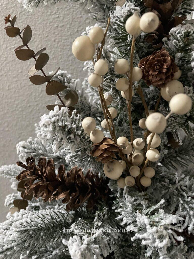 Neutral berries and pinecones on a wreath. 