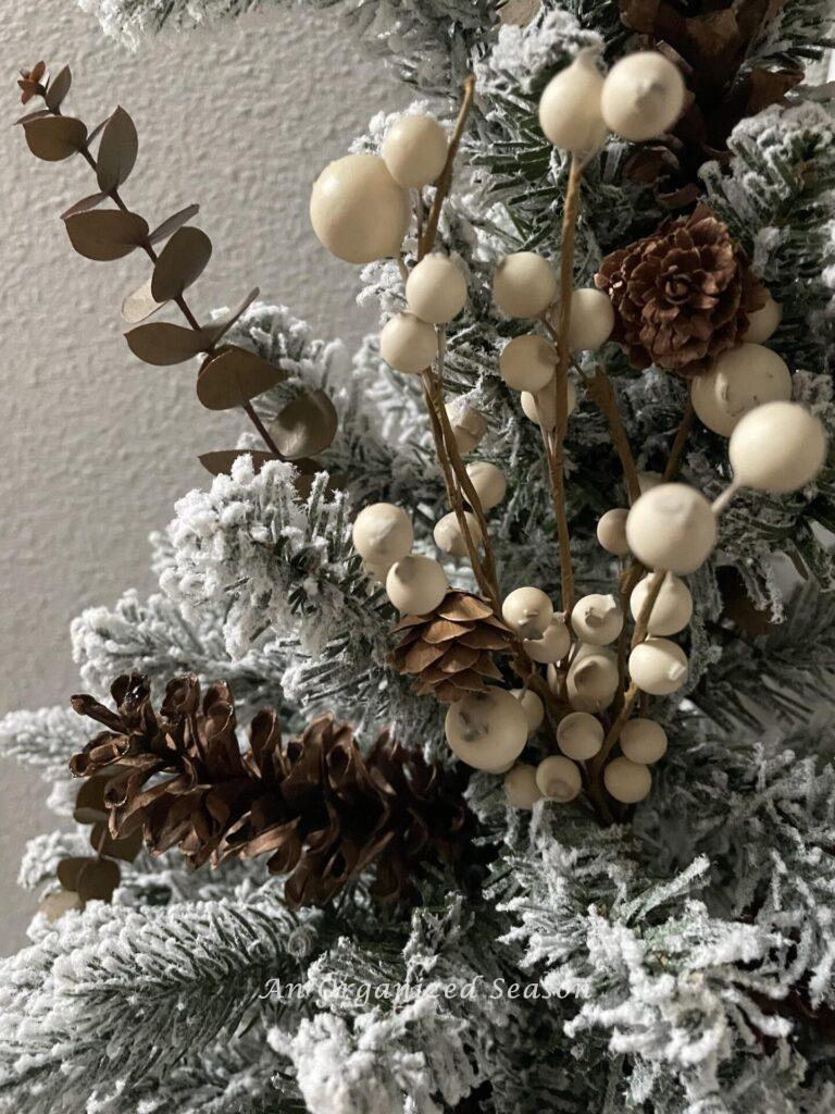 Neutral berries and pinecones on a wreath.