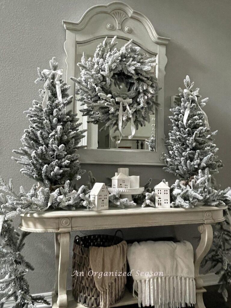 A King of Christmas queen flocked set decorated for Winter and displayed on a foyer console table. 