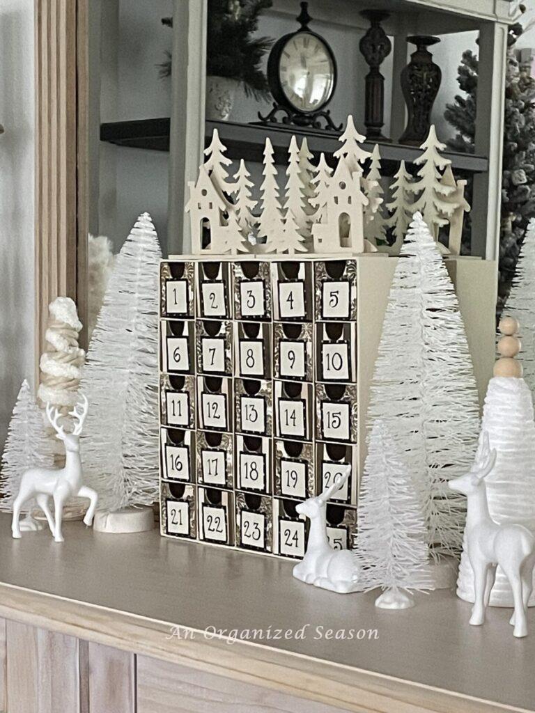 An Advent calendar with wood cutout trees on top of it! 