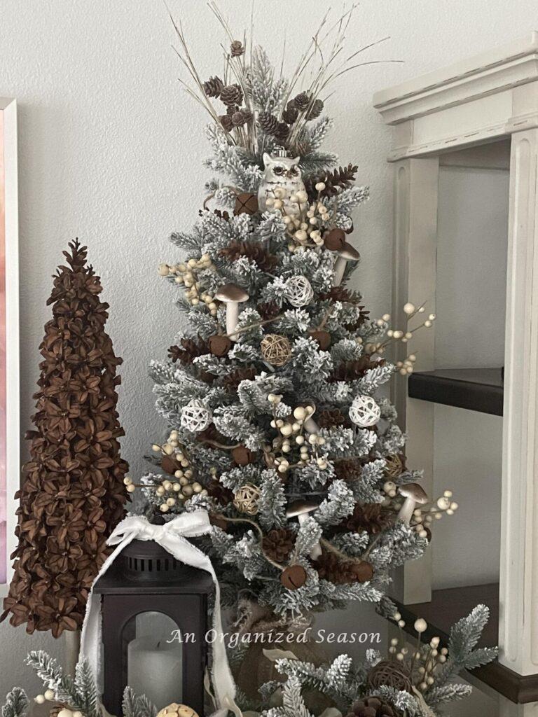 A decorated tabletop Christmas tree next to a Pinecone flower Christmas tree. 
