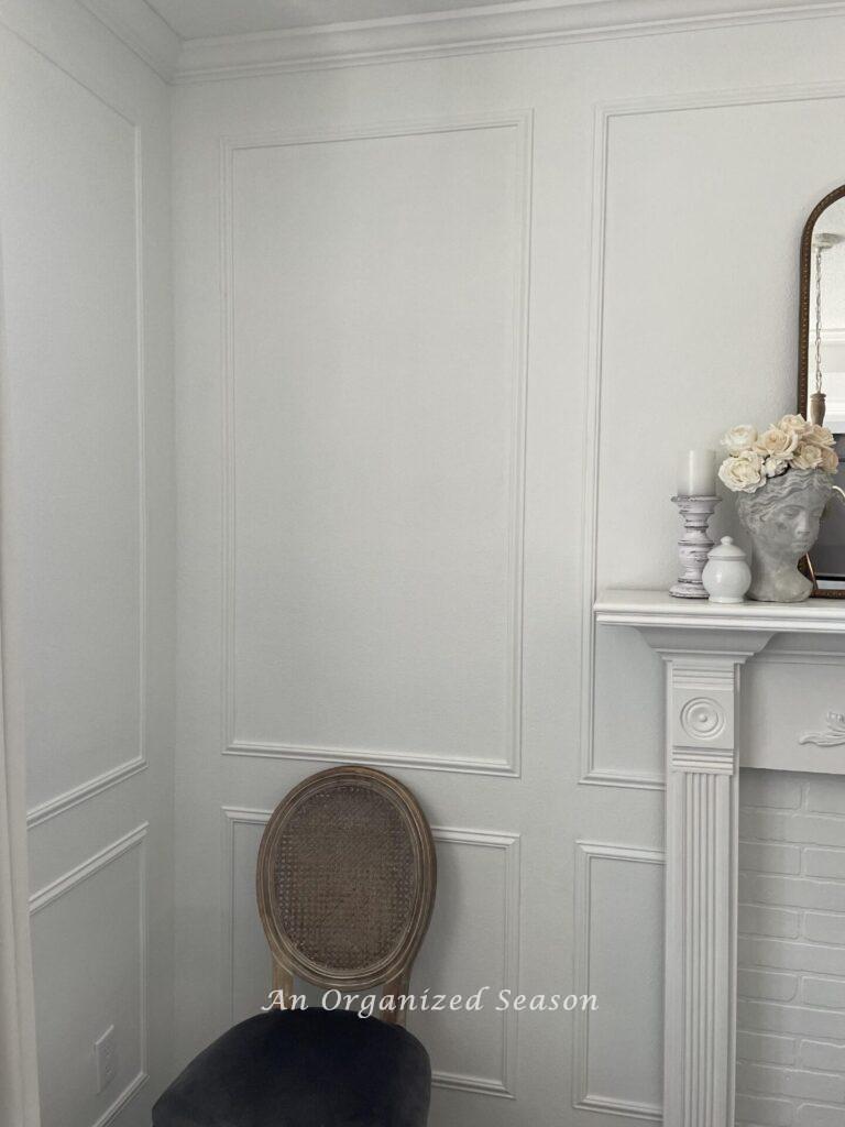 A white room with crown molding and picture frame trim on the walls. 