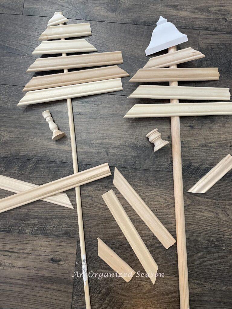 Step one to make a wooden Christmas tree is to plan your design of scrap wood pieces, candlesticks, and dowel rods.