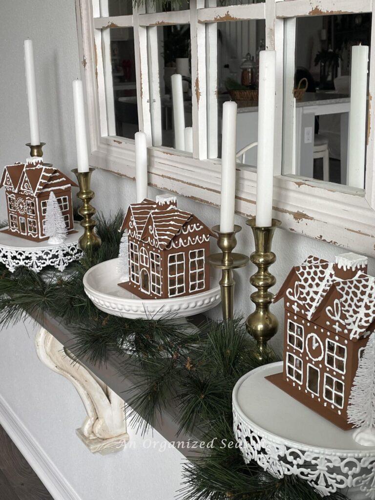 DIY gingerbread houses displayed on white cake plates make perfect  Christmas kitchen decor.