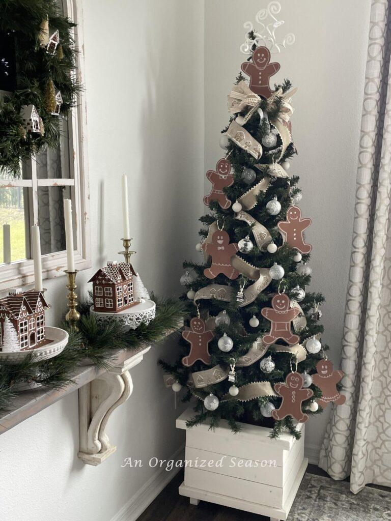 A Christmas tree decorated with gingerbread people and ribbons. 