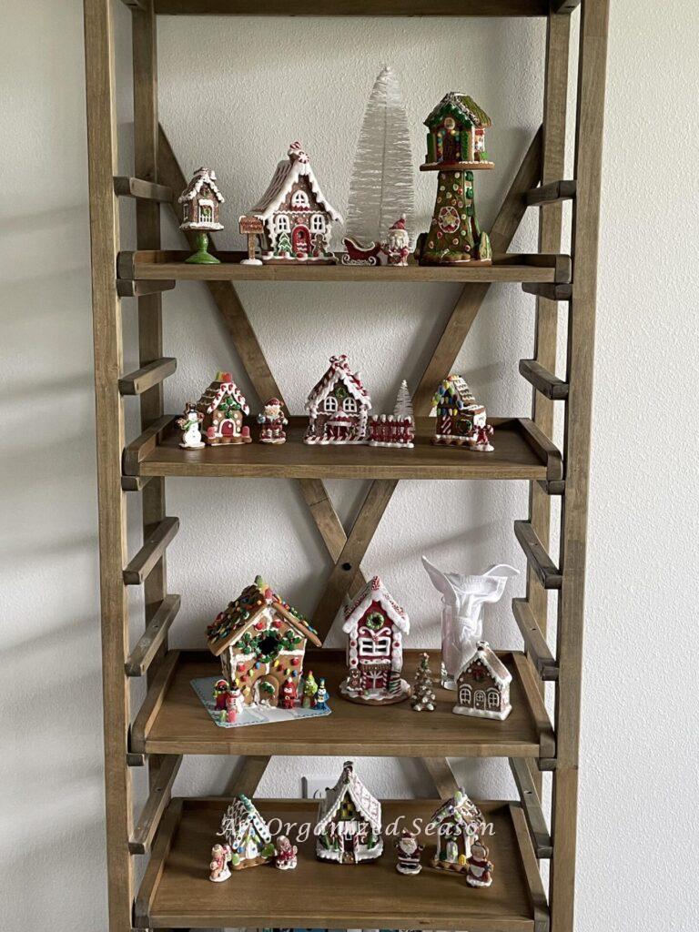 A gingerbread house village displayed on pie shelves.