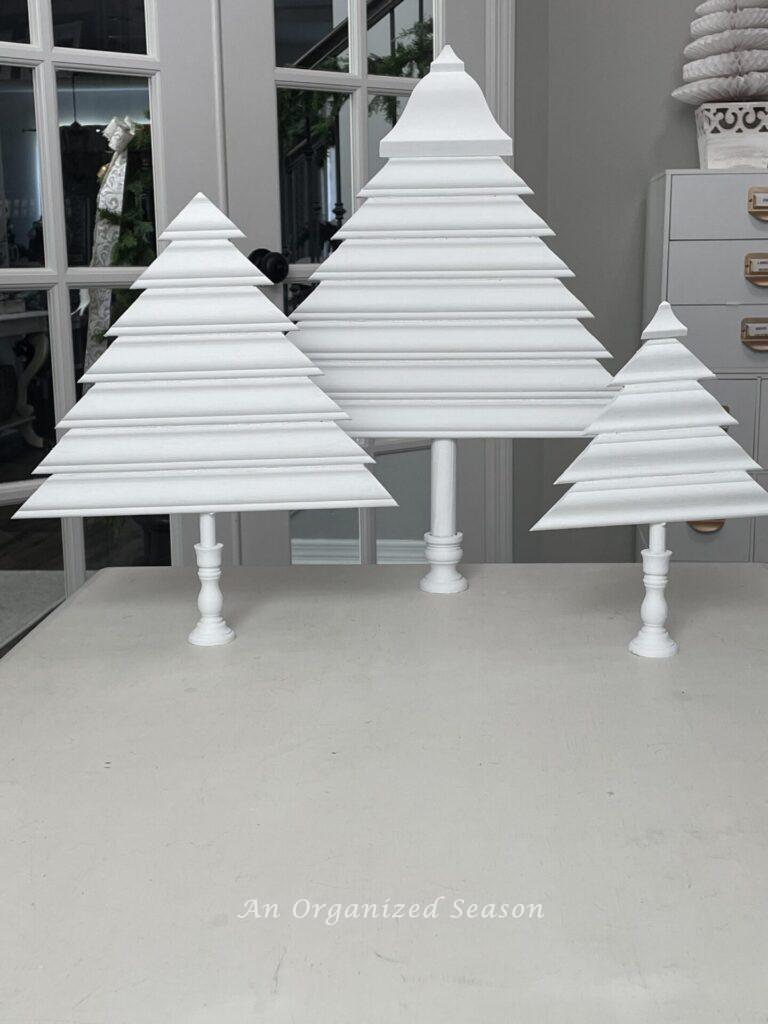 Step six to make a wooden Christmas tree is to paint it white. 