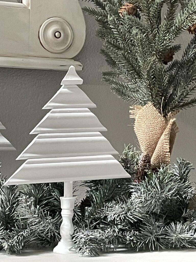 A white Christmas tree made of wood trim and a candlestick holder. 