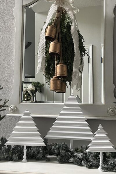 Three DIY wooden Christmas trees on a foyer table.