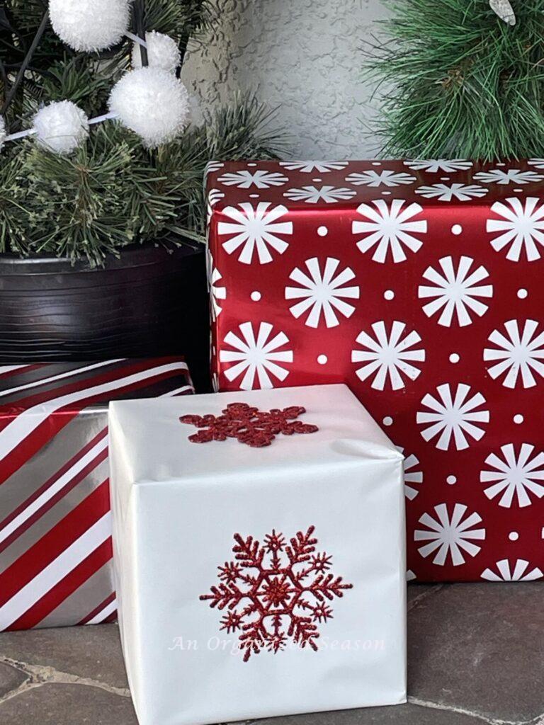 Faux gifts wrapped in red and white make festive Christmas porch decor.