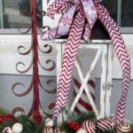 A red metal tree and white lantern decorated with red and white ribbon.