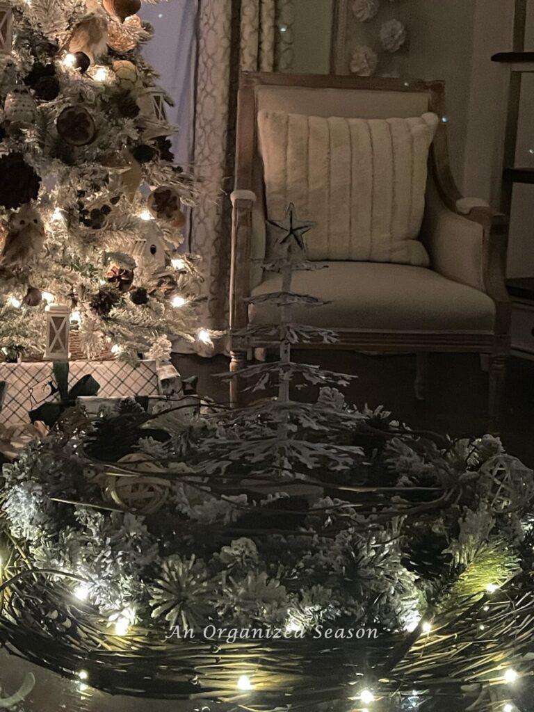 A centerpiece on a coffee table made with a grapevine wreath wrapped in fairy lights.  