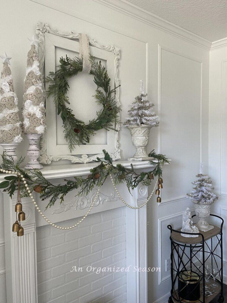 A fireplace decorated for Christmas and a bar cart next to it.