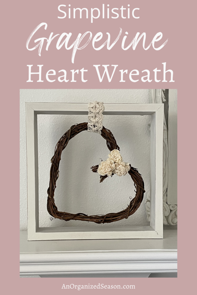 Grapevine heart wreath hanging in a square frame. 