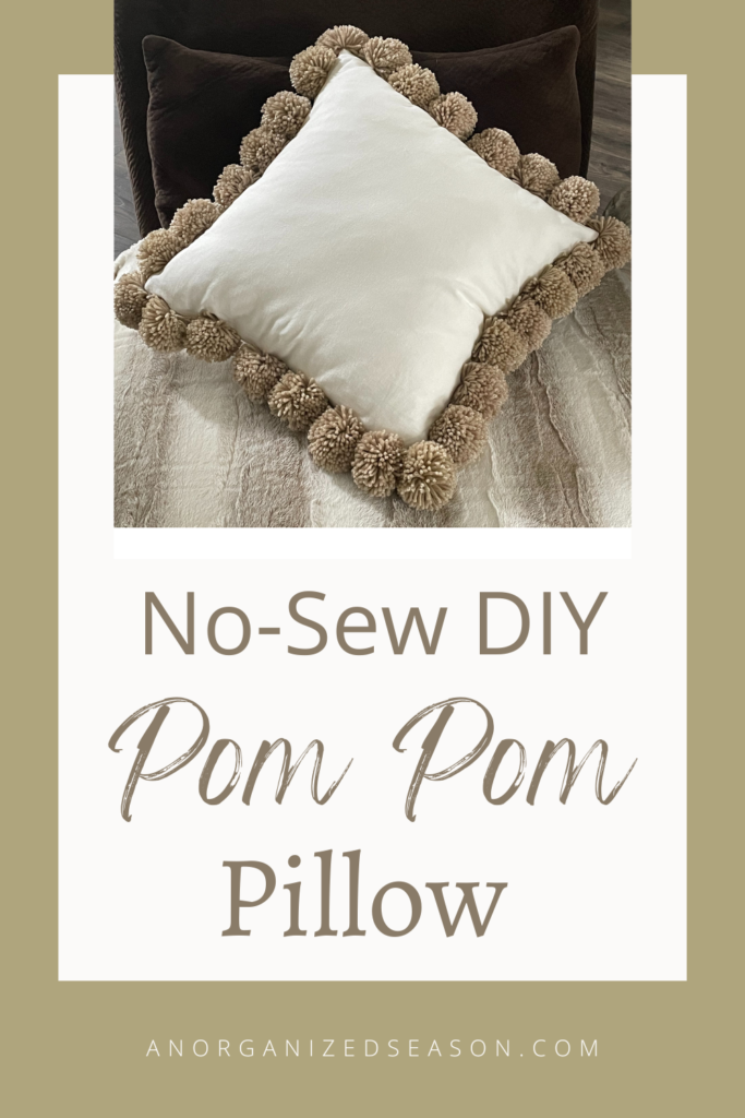 A pom pom pillow on a faux fur throw. 