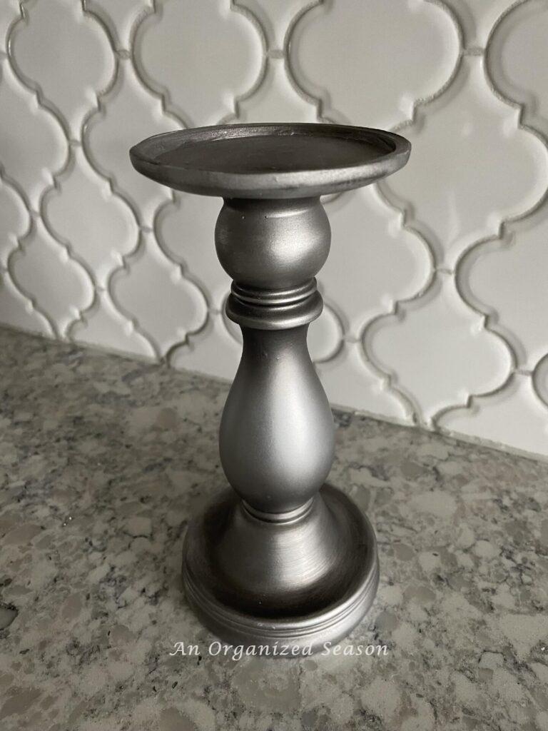 A silver candlestick sitting on a kitchen counter. candlestick. 