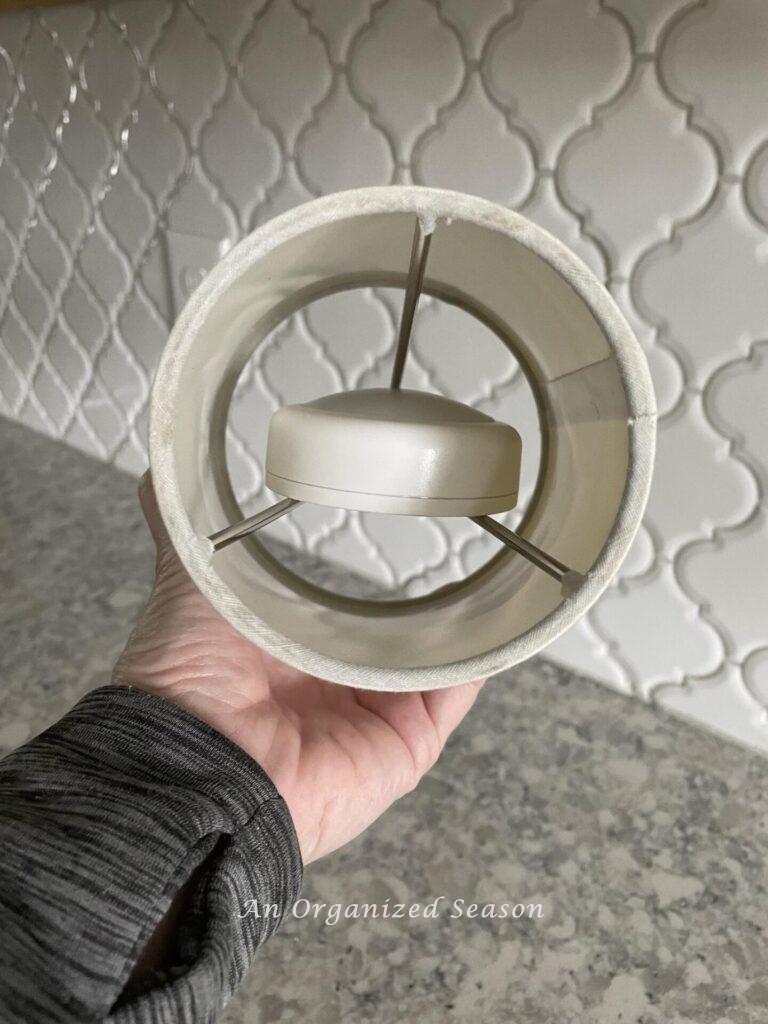 Step two make a DIY lamp is to place the puck light inside the lampshade.