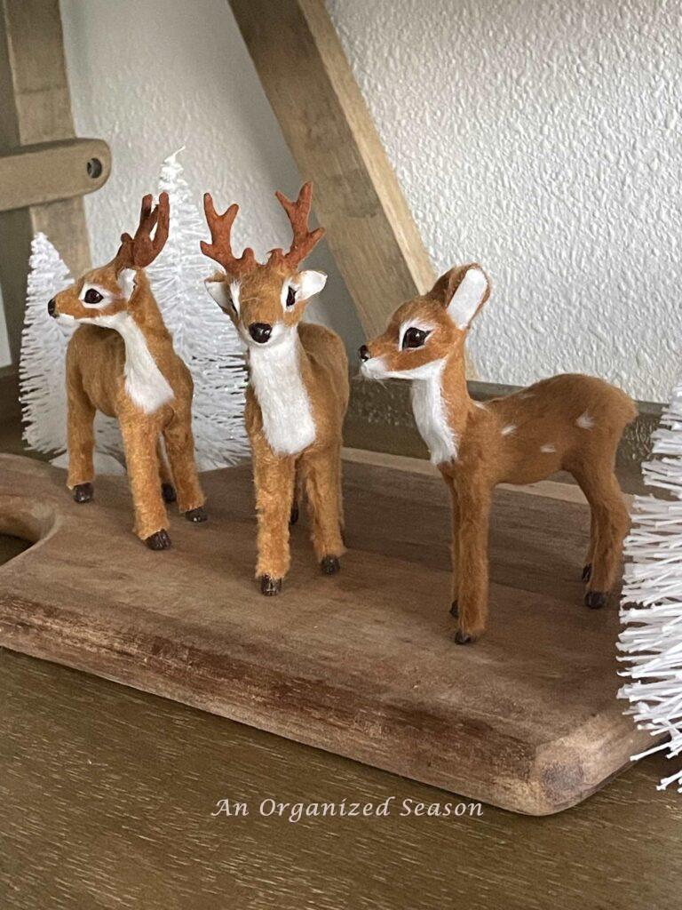 Put three miniature deer on a cutting board for Winter decor. 
