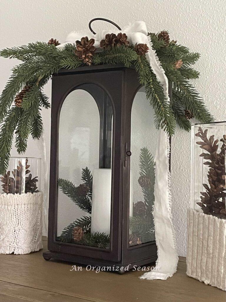 Brown lantern decorated with evergreen and pinecones makes perfect winter decor. 