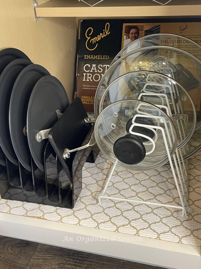 Lids of pots and pans are organized and stored on a rack. 