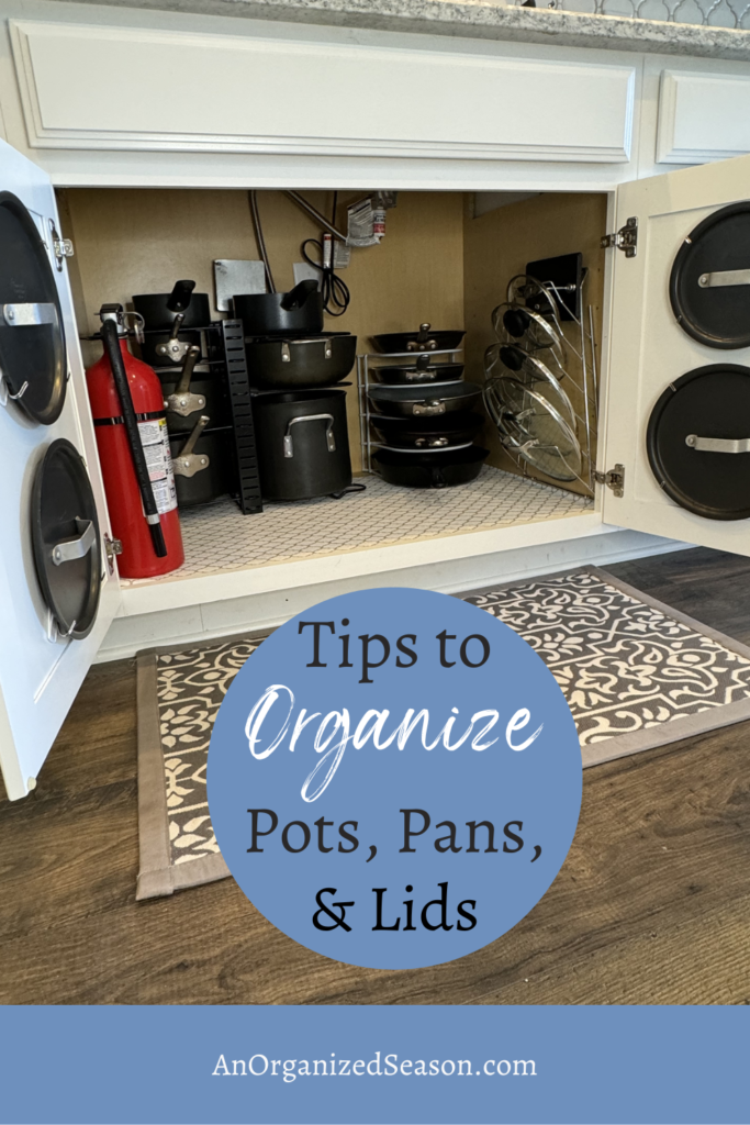 Pots, pans, and lids organized on racks in a cabinet. 