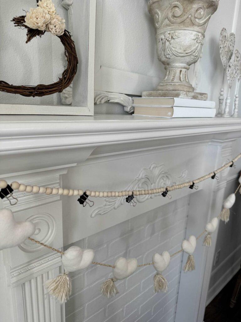 Use clips on a wood bead garland to decide where the pom poms will go. 