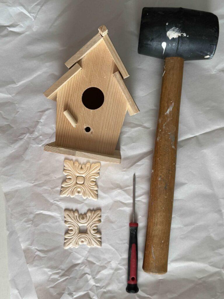 Wood birdhouse, appliques, a small screwdriver and a mallet. 
