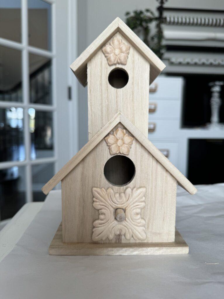 Wood appliques glued onto a birdhouse.