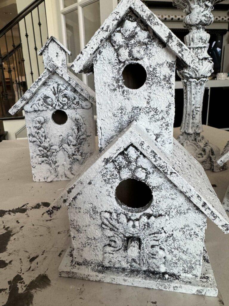 Birdhouses and candlesticks painted white. 