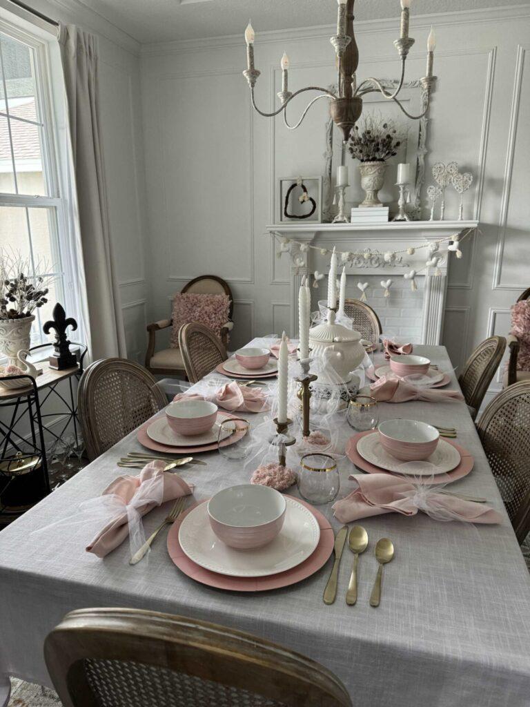 A white dining room decorated for Valentine's day with pink items. 