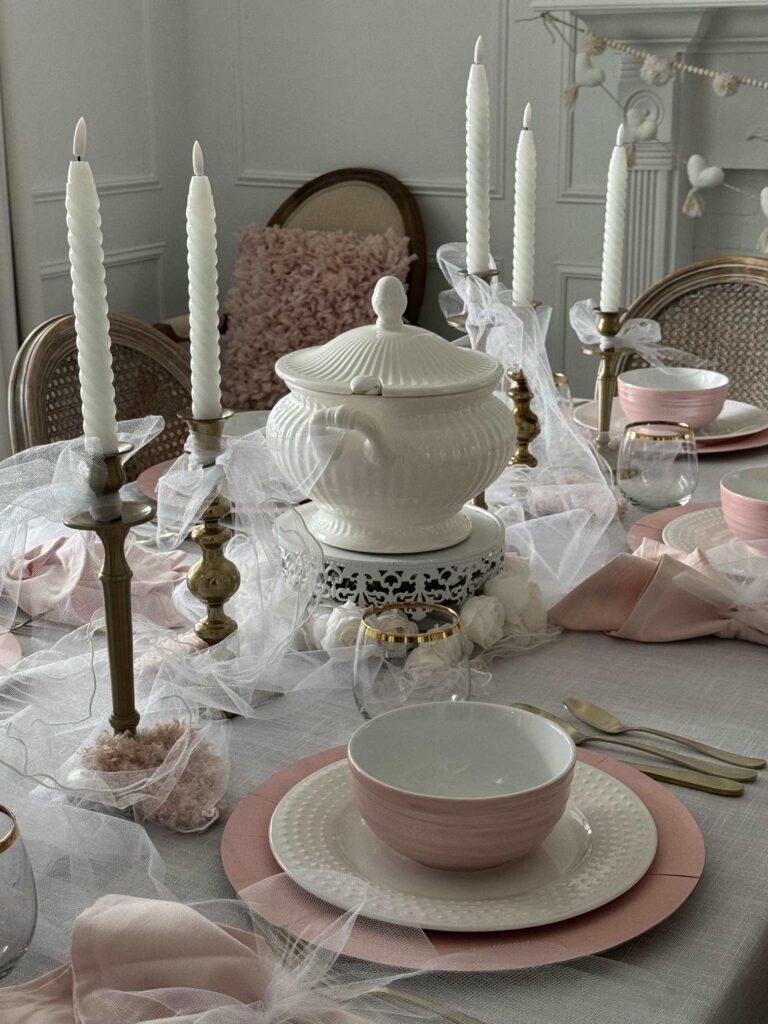 A dining table decorated for Valentine's Day with pink and white dishes. 