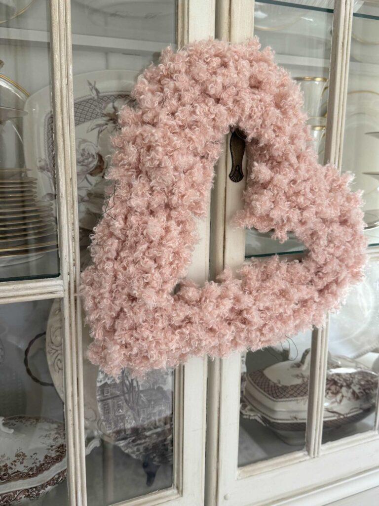 Pink heart wreath made from yarn. 