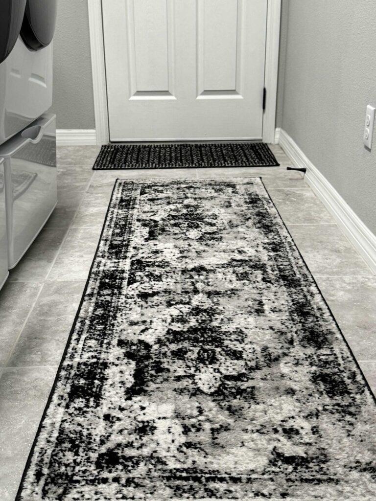 A door mat and runner on the laundry room floor. 