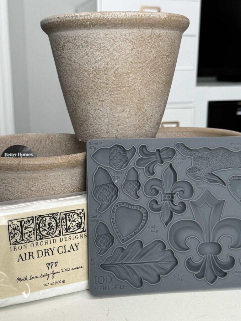 Three flower pots, air-dry clay and an IOD mould used to make DIY flower pots.