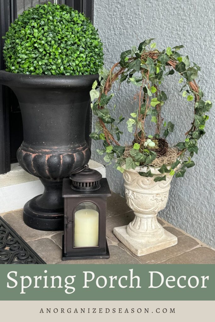 Two planters with topiaries and a brown lantern. 