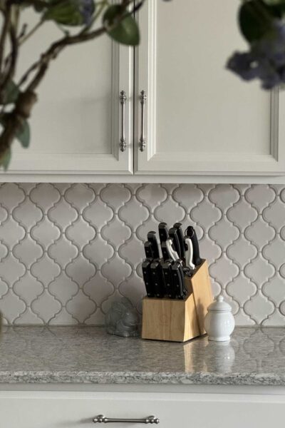 Silver cabinet hardware on white kitchen cabinets.