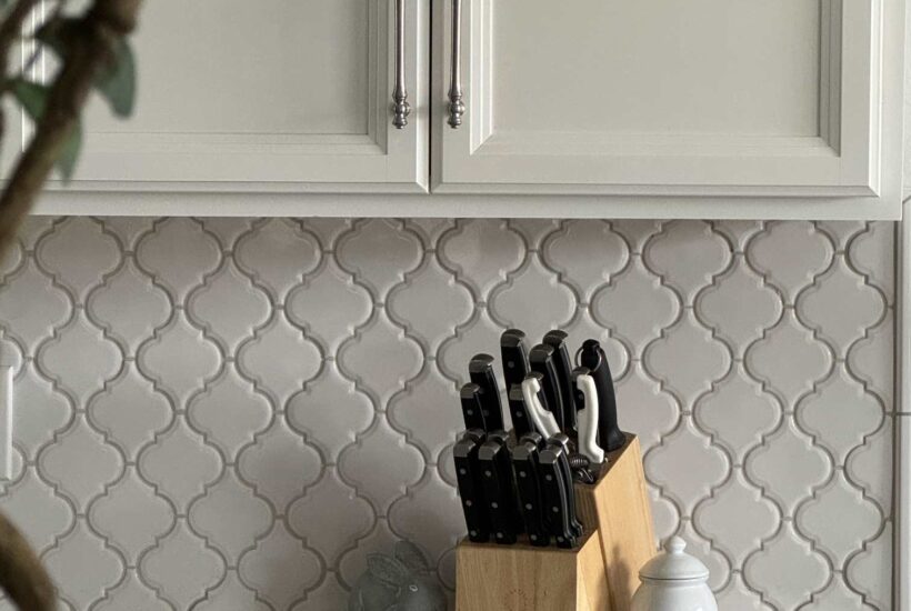 Silver cabinet hardware on white kitchen cabinets.