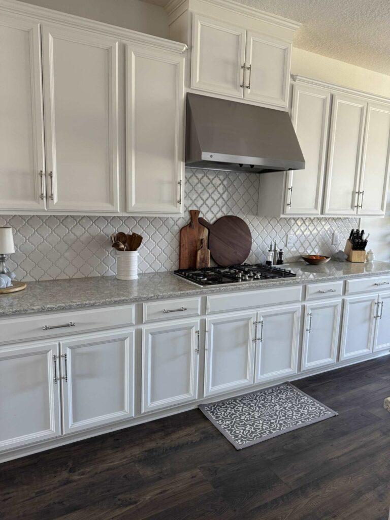 A white kitchen with silver hardware. 