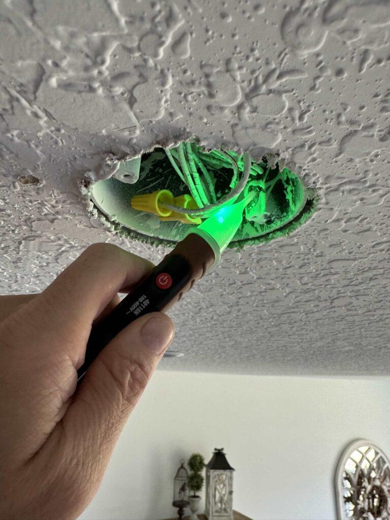 Voltage detector that has turned green when checking ceiling wires. 