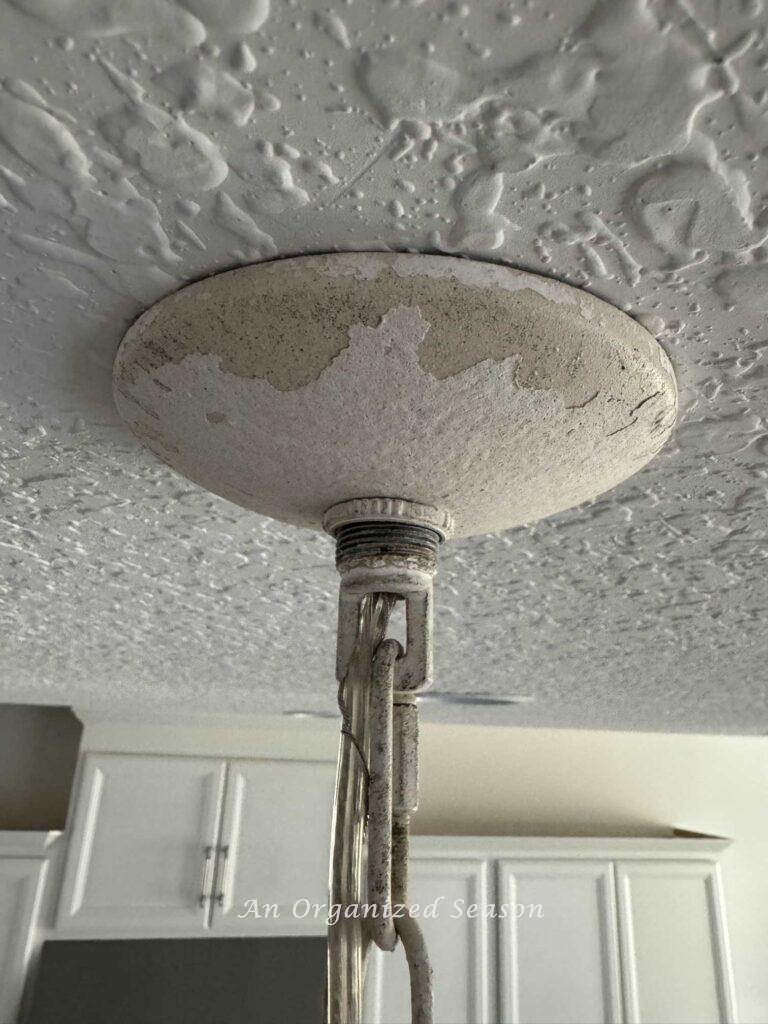 Ceiling light fixture cover attached to kitchen ceiling.